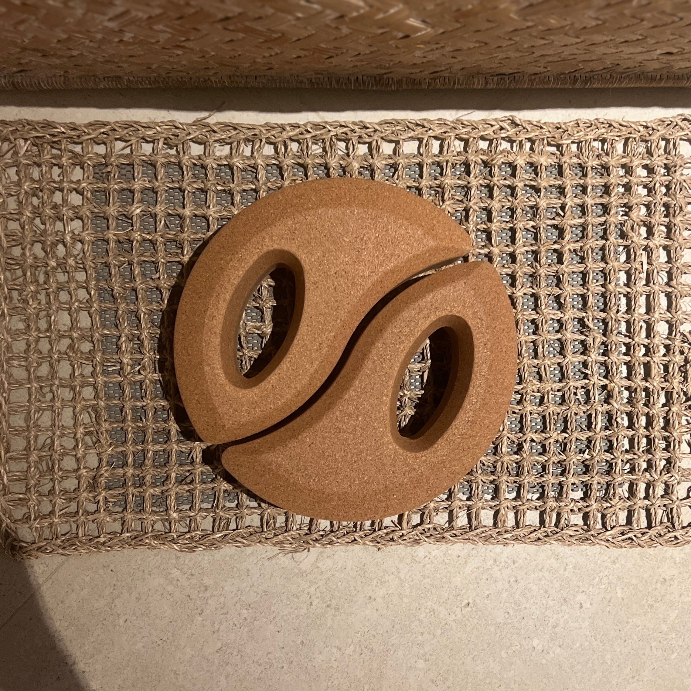 Tai Chi Balance Block forming a yin-yang on a woven mat